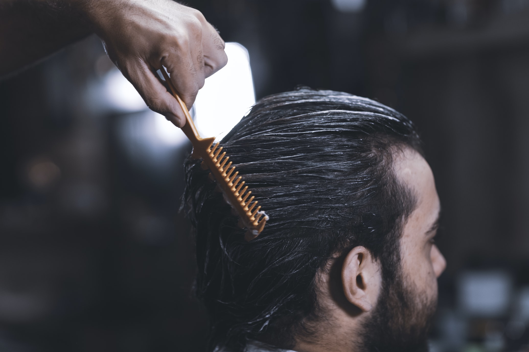 combing hair of barbershop client